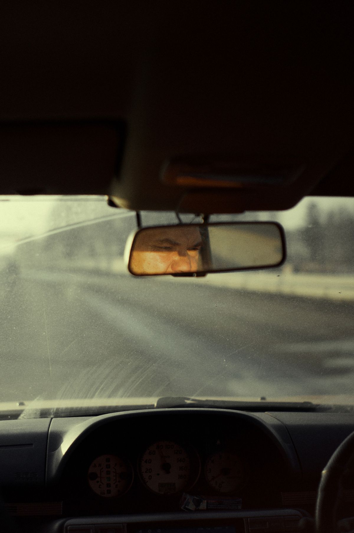 Driver checking rearview mirror as part of defensive driving technique